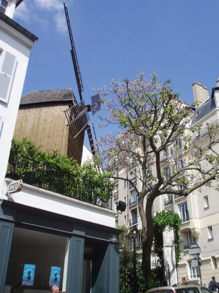 Skręcając za młynem w lewo, wchodzimy w rue Girardon, która biegnie wzdłuż białego budynku widocznego na zdjęciu.